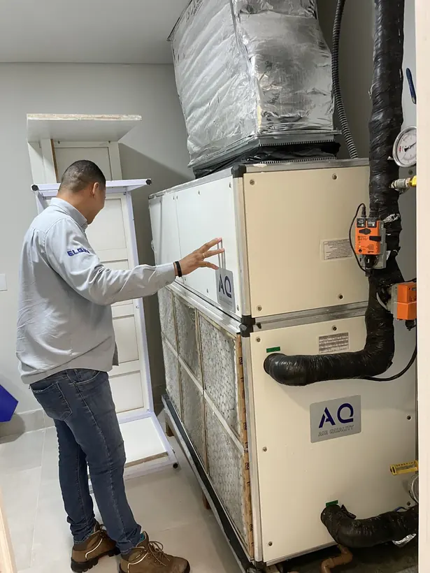 Técnico realizando manutenção em equipamento de climatização comercial