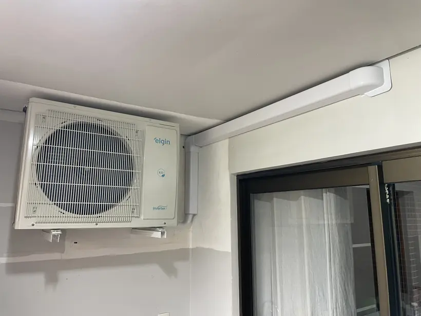 Condensadora instalada em parede externa ao lado de uma janela